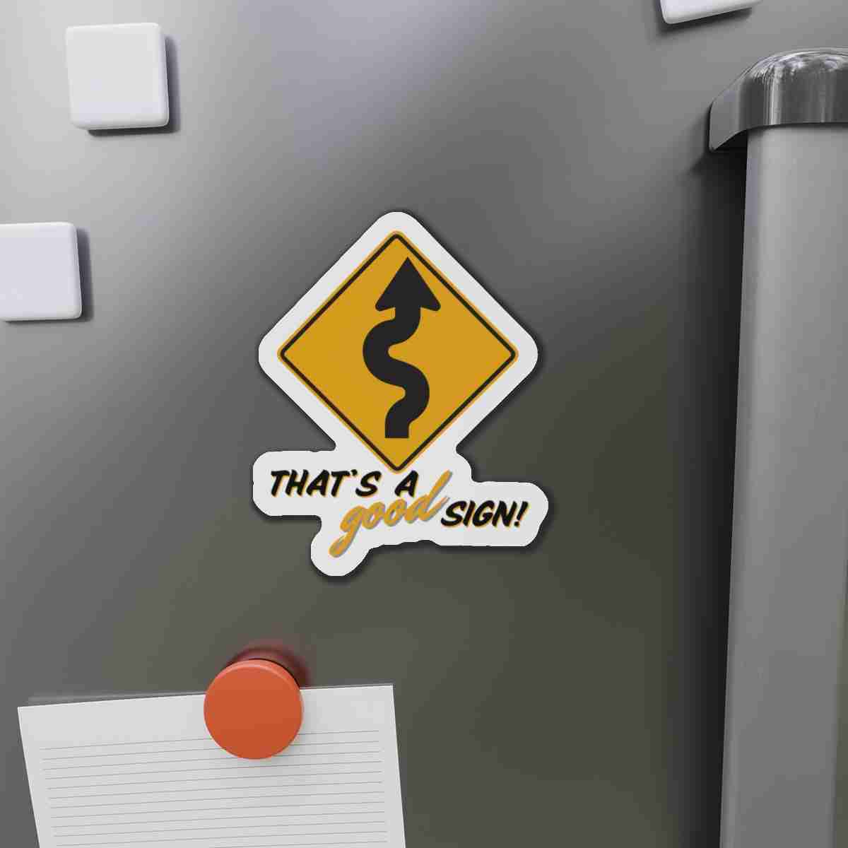 Humorous sticker of a winding road warning sign on a gray metal surface, with the caption 'That's a good sign!'